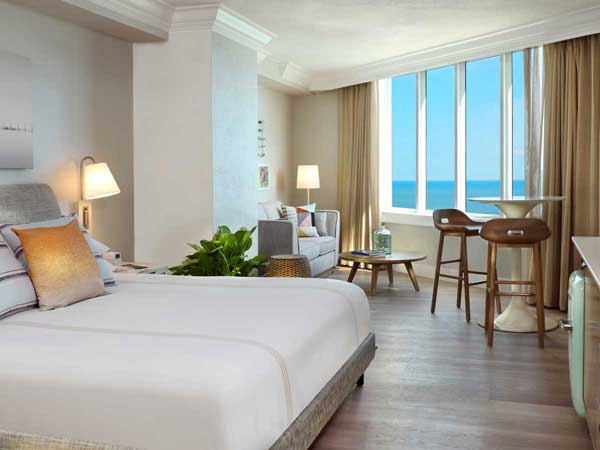 guest room with bed and ocean view.