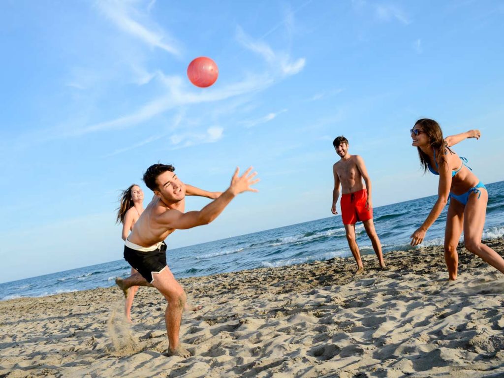 Group Playing Beach Volleyball At Pelican.